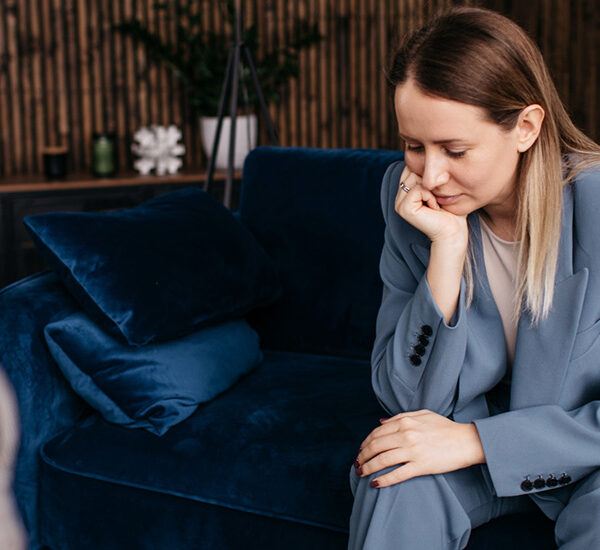Young woman sad on blue velvet couch