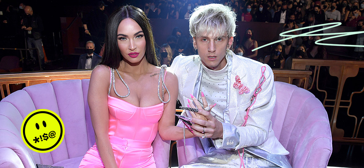 Megan Fox and Machine Gun Kelly sit on a pink couch holding hands