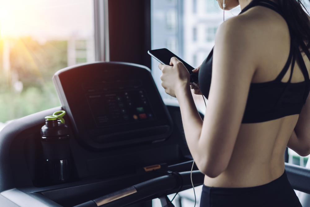 Woman,Cardio,Running,Workout,Listening,Music,Using,Earphones,Holding,Smartphone