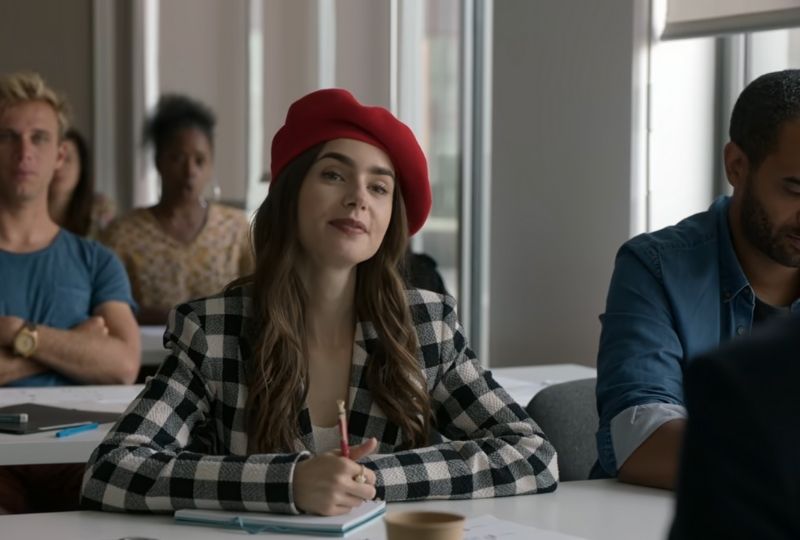 Lily Collins in Emily in Paris wearing a red beret and black and white paid jacket.