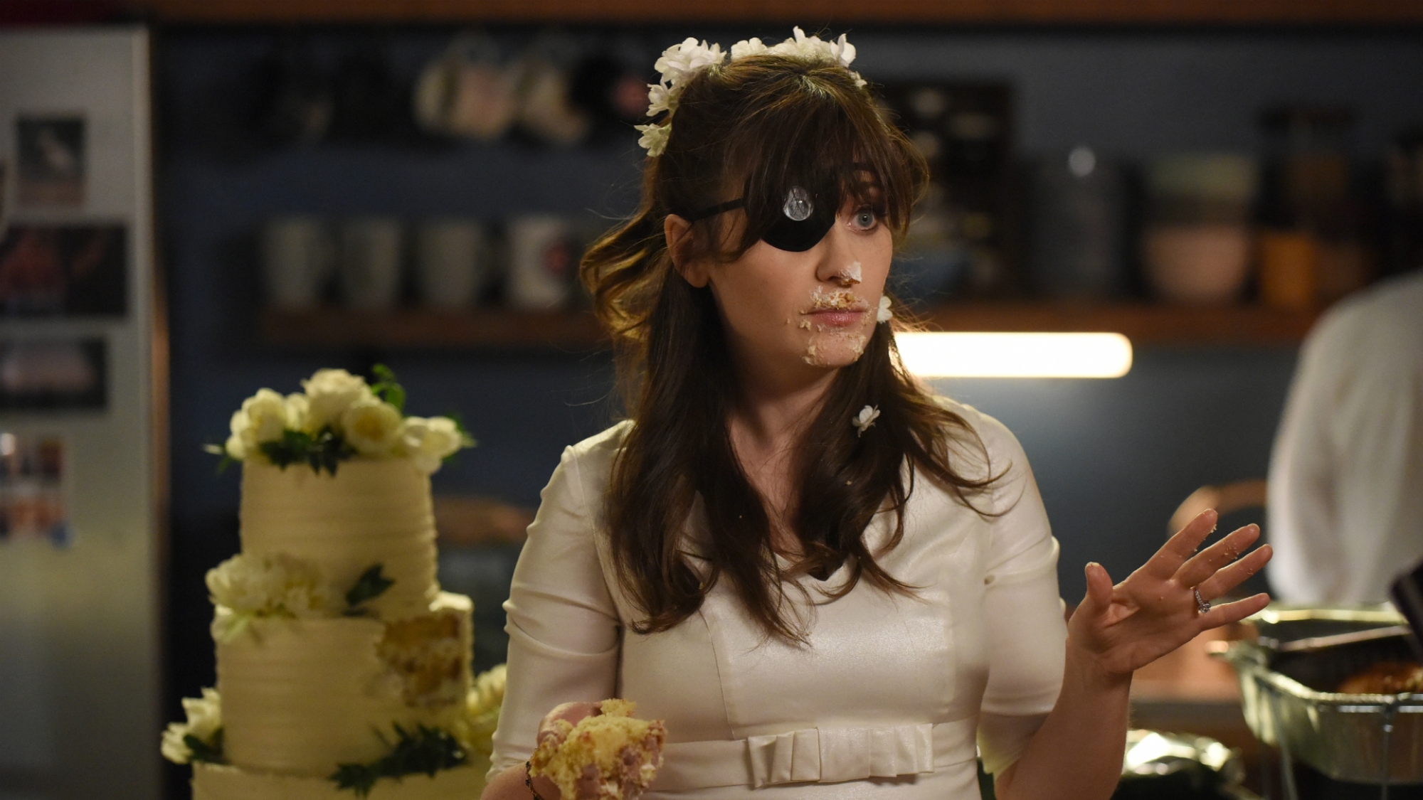 Jess is dressed in her wedding gown and eye patch.