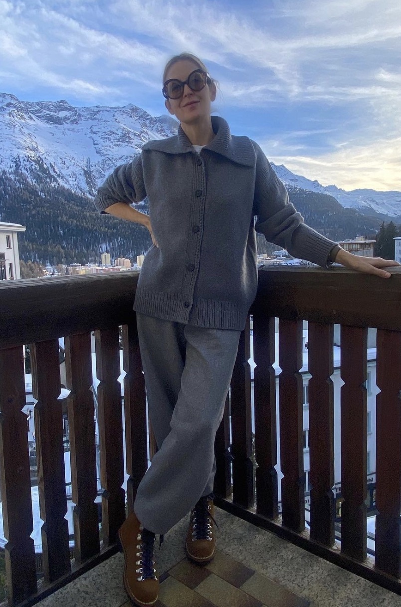 Kelly Rutherford posing in front of a winter mountain scene in a nice sweat set.