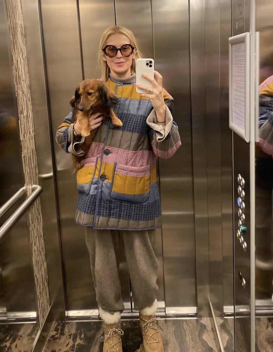 Kelly Rutherford holding her dog in an elevator wearing sunglasses while taking a mirror selfie