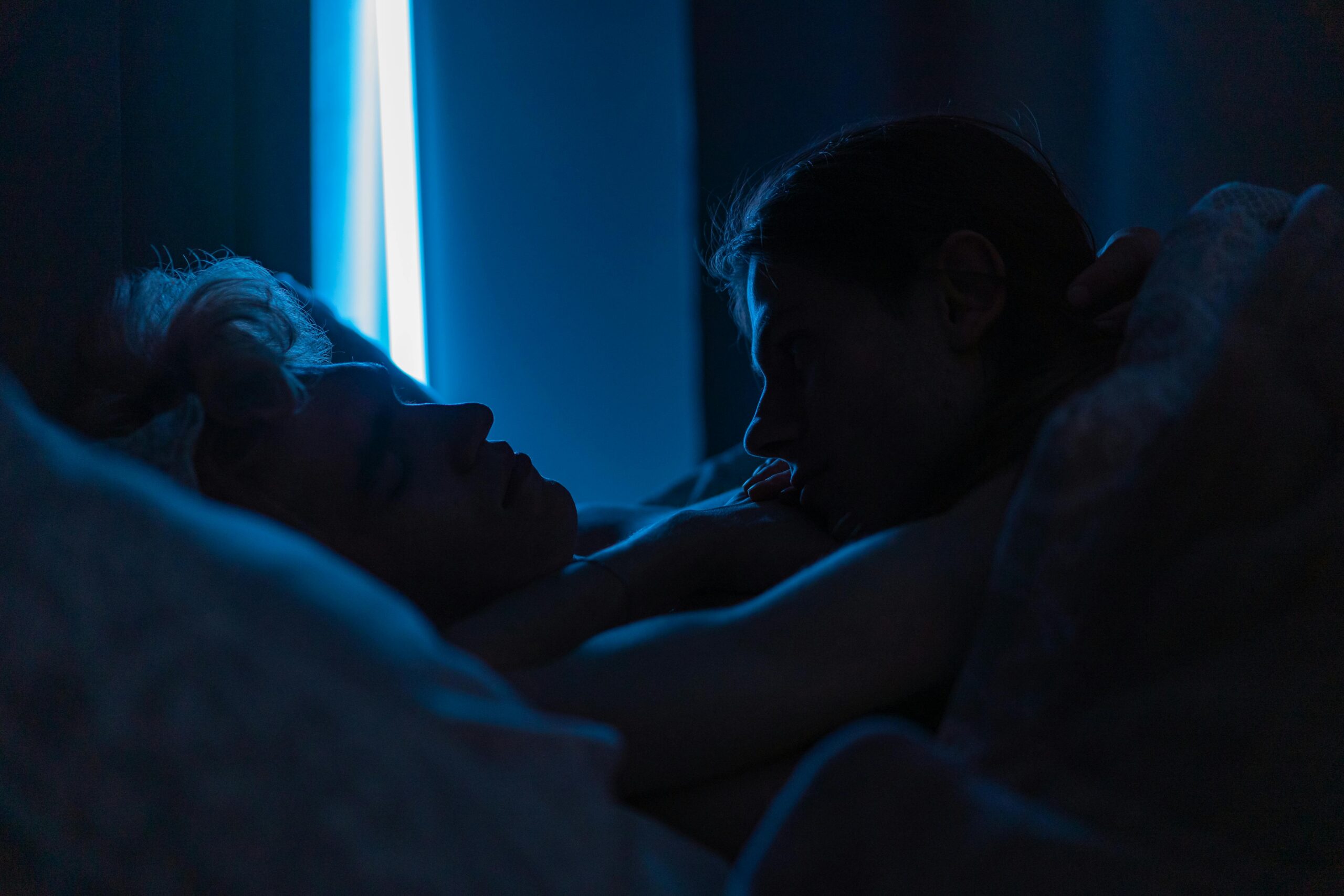 couple laying in bed in dark