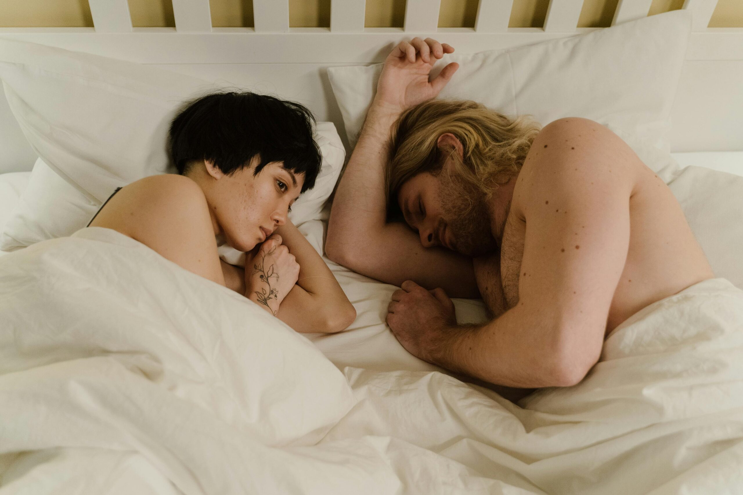 woman awake next to sleeping man