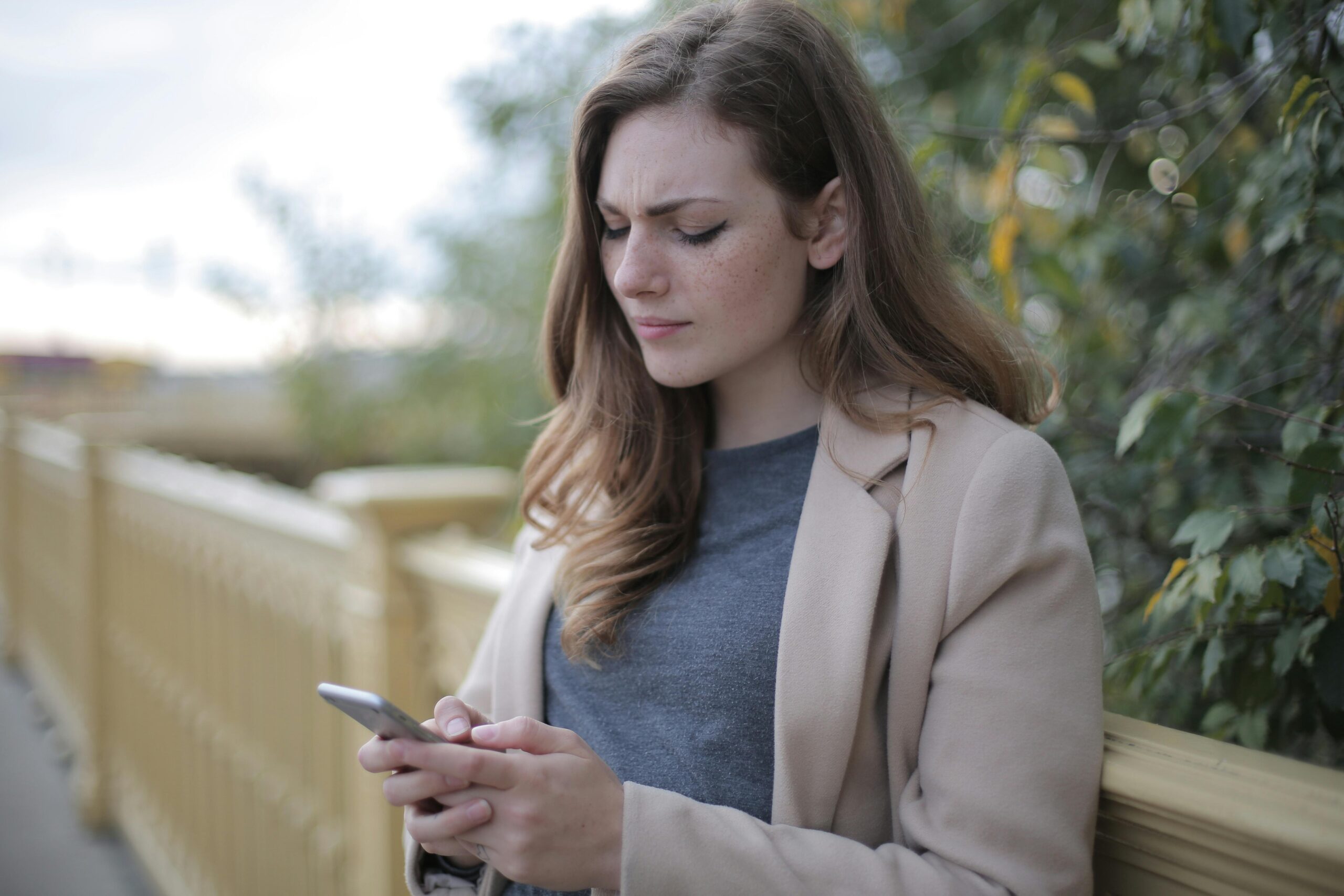 woman looking at phone upset