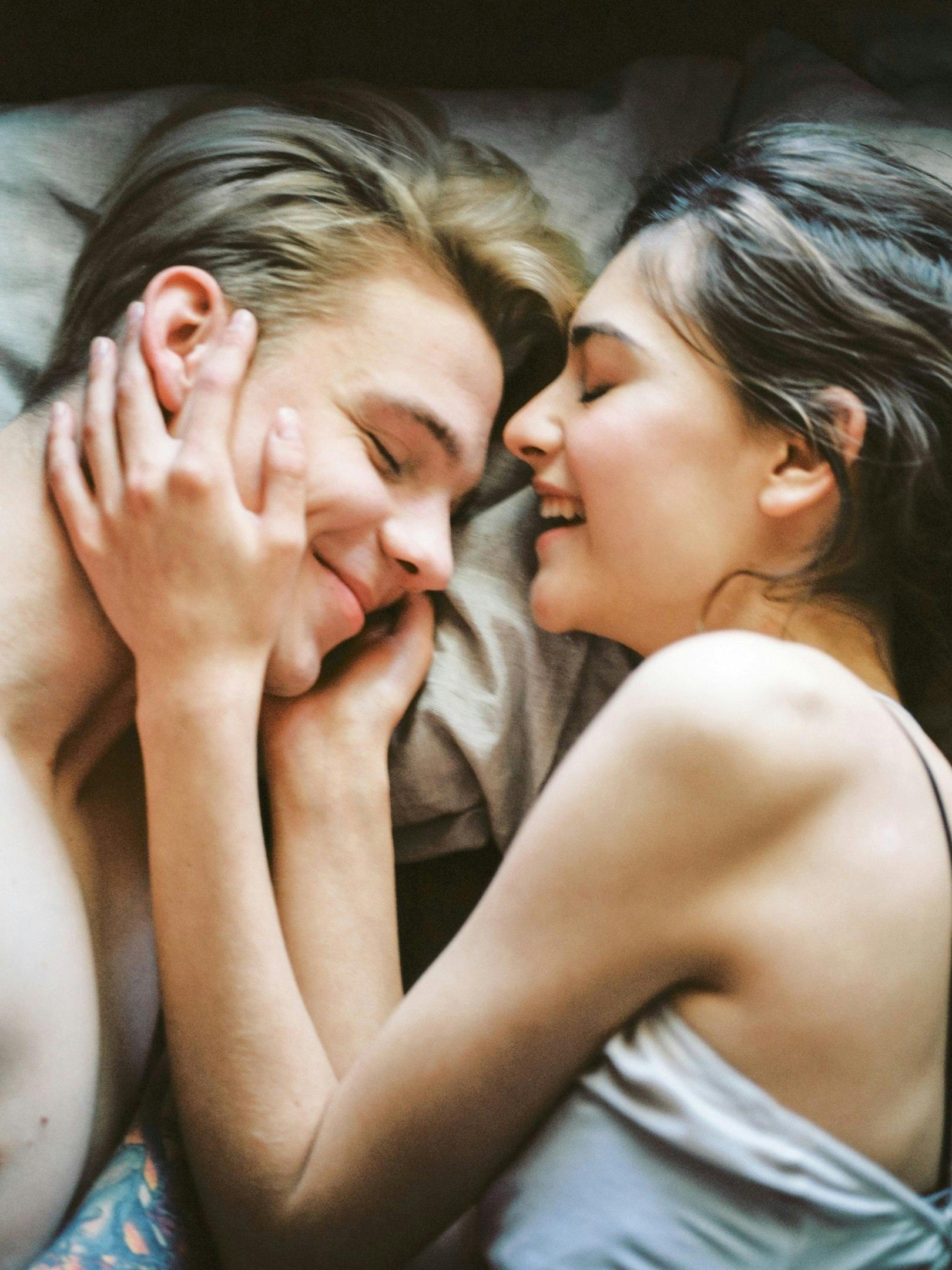 couple smiling in bed naked